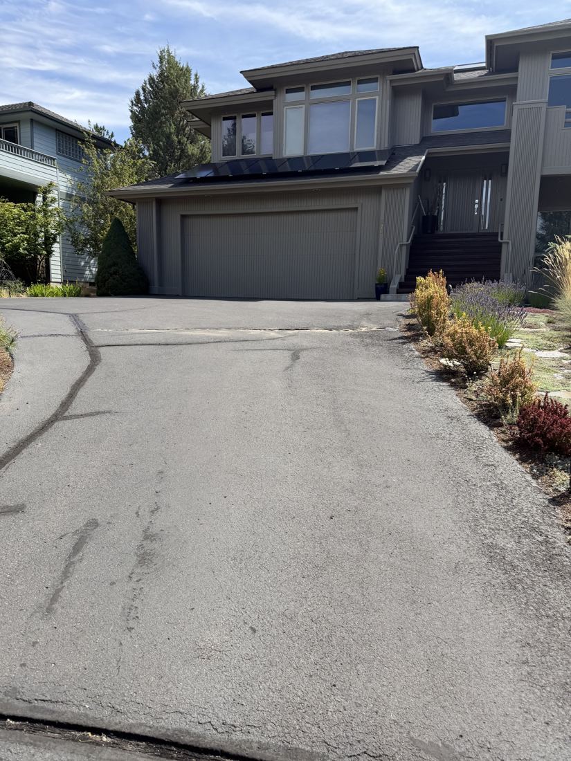 Before: grey, oxidized driveway with visible cracks and patch lines